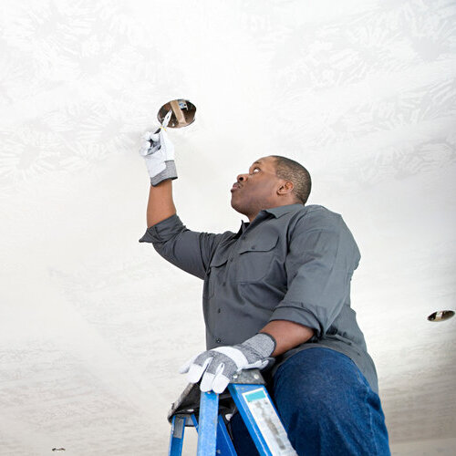 electrician installing ceiling light